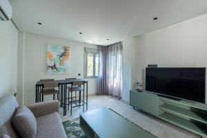 a living room with a couch and a flat screen tv at ON City Apartments in Matalascañas