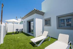 a yard with two chairs and a building at ON City Apartments in Matalascañas