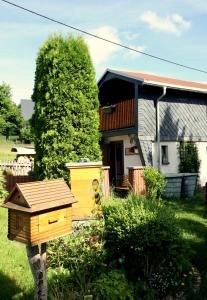 uma casa com um pássaro amarelo casa no quintal em Ferienhaus beim Imker em Marienberg