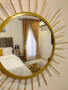 a large gold mirror in a bedroom with a bed at HOMEDALES Freedom Way LEKKI Phase1 LAGOS in Lekki
