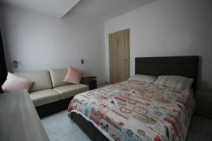 - une chambre avec un lit et un canapé dans l'établissement BF RESIDENCE, à San Pawl il-Baħar
