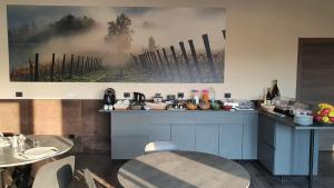 ORIZZONTI Vigneti Repetto في Sarezzano: مطبخ مع طاولة و لوحة على الحائط