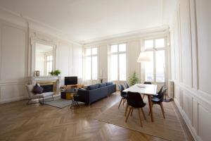 a living room with a couch and a table and chairs at Appartement sur les quais de Bordeaux in Bordeaux