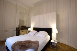 - une chambre avec un grand lit blanc et une fausse couverture en fourrure dans l'établissement Appartement sur les quais de Bordeaux, à Bordeaux