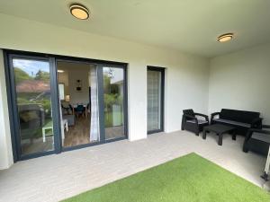 a living room with a couch and chairs and a patio at Aranyhíd Deluxe Apartman in Balatonalmádi