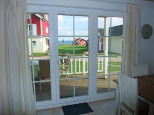 an open door to a balcony with a view of the ocean at Strandpark Sierksdorf H073 in Sierksdorf