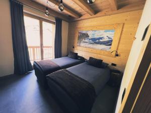 利維尼奧的住宿－Carosello Lodge Livigno，小木屋内一间卧室,配有两张床