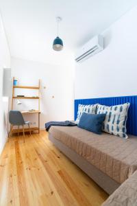 um quarto com uma cama e uma secretária com uma cadeira em Blue by the River 1 - elegant two-bedroom in Santos em Lisboa