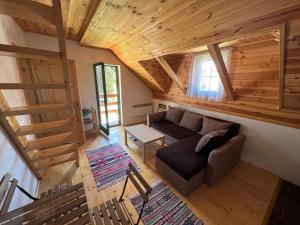 sala de estar con sofá y techo de madera en Dormire Apartmans, en Žabljak