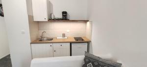a small kitchen with white cabinets and a sink at Nora Norita in Batsi