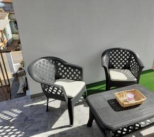 2 sillas y una mesa en el patio en Grazioso bilocale in centro, en Lotzorai