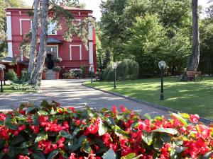 una casa roja con un jardín de flores rojas en Willa Impresja Hotel i Restauracja en Pabianice