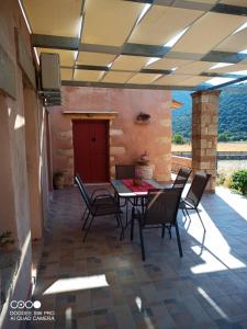 a patio with a table and chairs on it at villa archontiko ASKYFOU SFAKIA in Karés