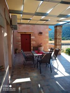 eine Terrasse mit einem Tisch und Stühlen darauf in der Unterkunft villa archontiko ASKYFOU SFAKIA in Karés