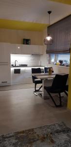 Una cocina con una mesa y sillas y un fregadero. en Alex Apartman, en Békéscsaba