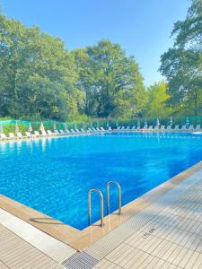 a large swimming pool with chairs and blue water at Meselik Park Bungalov in Sapanca