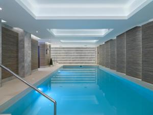 ein Schwimmbad mit blauem Wasser in einem Gebäude in der Unterkunft Hotel Sheraton in Blackpool