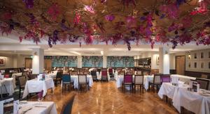 ein Esszimmer mit weißen Tischen und Stühlen und Blumen in der Unterkunft Hotel Sheraton in Blackpool
