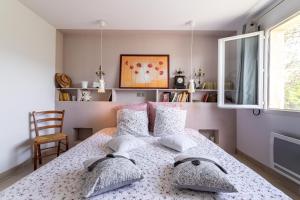 a bedroom with a bed with pillows and a window at Villa Clémentine in Gravières