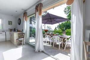 a kitchen and dining room with a table with an umbrella at Villa Clémentine in Gravières