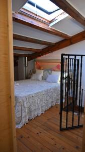 Casa Rural Antigua Botica في Torremocha de Jarama: غرفة نوم بسرير ابيض مع سقف