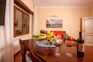 a table with a bowl of fruit and two glasses of wine at IBibiena - CASA DI DIEGO in Bibbiena