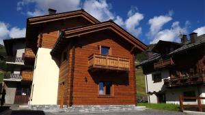 a wooden building with a balcony on the side of it at Central Rin in Livigno