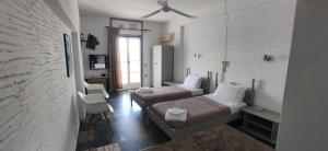 a hotel room with two beds and a window at Nora Norita in Batsi