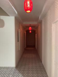einen leeren Flur mit zwei roten Lichtern und einem langen Korridor in der Unterkunft 2499 Heritage Chinatown Bangkok Hotel By RoomQuest in Pom Prap