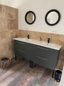 een badkamer met twee wastafels en twee spiegels aan de muur bij Maison de charme avec piscine in Monteux