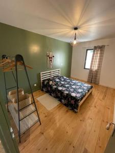 um quarto com uma cama e piso em madeira em Maison de charme avec piscine em Monteux