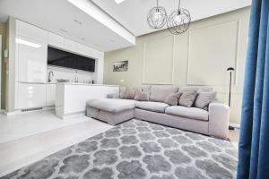 a living room with a couch and a kitchen at Dune Beach Resort in Mielno