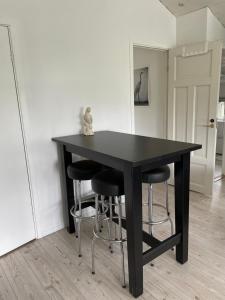 a black table with four stools in a room at Villa Båthamnsgatan in Söråker