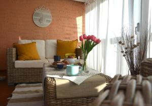 ein Wohnzimmer mit einem Sofa und einem Tisch mit Blumen in der Unterkunft Villa Vittoria in San Teodoro