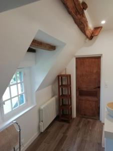 a room with a staircase and a wooden door at Chambre d'Hôte Près de Deauville in Surville