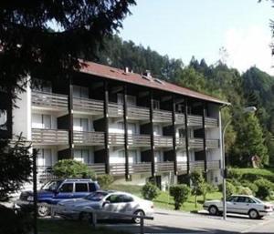 un gran edificio con coches estacionados frente a él en Haus-Sonnenbichl-Wohnung-102, en Oberstdorf