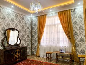 a room with a table and a mirror and a window at Safar Guest House in Samarkand