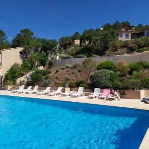una piscina con sedie a sdraio e un resort di les issambres, appt 4 personnes, vue mer golf st tropez a Les Issambres