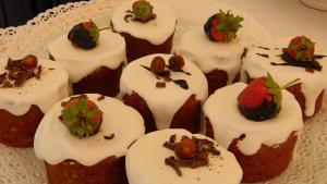 a bunch of cupcakes with white frosting and a strawberry at Relais Fenicottero Rosa in Porto San Paolo