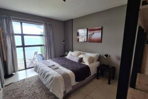 a bedroom with a bed and a large window at Elpizo Vista in East London