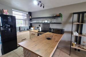 a kitchen with a wooden table and a black refrigerator at Elpizo Vista in East London