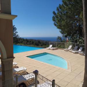 - une piscine dans une terrasse entourée de chaises longues dans l'établissement les issambres, appt 4 personnes, vue mer golf st tropez, aux Issambres