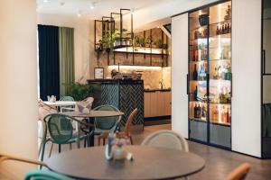 a restaurant with tables and chairs and shelves with wine bottles at Goda Hotel & Spa in Druskininkai