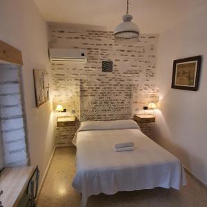 een slaapkamer met een wit bed en 2 nachtkastjes bij Recuerdos de la Abuela in Sevilla