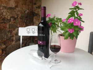 una bottiglia di vino e un bicchiere su un tavolo con una pianta di B&B Martina a San Vito