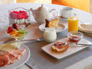 a table topped with plates of breakfast foods and orange juice at Relais Fenicottero Rosa in Porto San Paolo