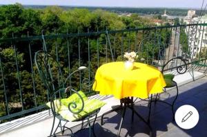 einen gelben Tisch und Stühle auf dem Balkon in der Unterkunft Apartment Bella Vista in Belgrad