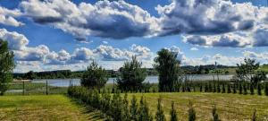 pole z rzeką i chmurami na niebie w obiekcie Gilužio Rivjera w Wilnie