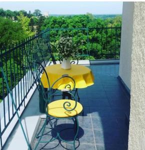 einen gelben Tisch und einen Stuhl auf dem Balkon in der Unterkunft Apartment Bella Vista in Belgrad