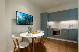 a kitchen with a white table and chairs and a kitchen with blue cabinets at LILO Loft - LIve with LOve in Heraklio